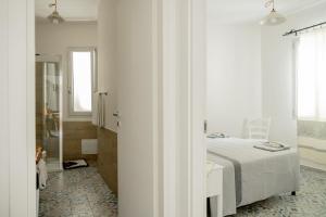 a white bedroom with a bed and a bathroom at Orosei365 in Orosei +38 photos