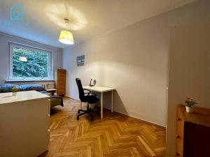a living room with a desk and a chair and a table at Surf Room - 5 Minutes to Sopot Molo & Seaside in Sopot