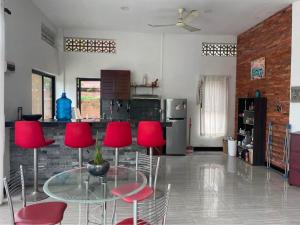a kitchen with red chairs and a glass table at Private Room with in-suite Bathroom - Lovely House with Garden in Phumĭ Réach Born