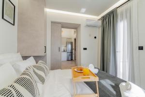 a bedroom with a white bed and a table at Urban Mountain Retreat in Kroústas