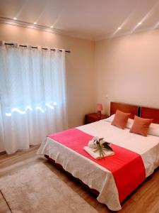 a bedroom with a large bed with a red and white blanket at Casa Luar- suite rooms in Praia do Carvoeiro +11 photos