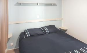 a bed with two black pillows in a room at Bungalow with Shared Pool in Pataias + 30 m² + Pool. in Pataias +22 photos