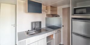 a small kitchen with a sink and a microwave at Bungalow with Shared Pool in Pataias + 30 m² + Pool. in Pataias