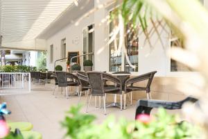 a patio with chairs and tables in a restaurant at Hotel Villa Perazzini in Rimini