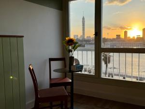 a room with a window with a table and a vase with a flower on at Nile View Luxury Apartment in Cairo +3 photos