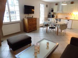 a living room with a table and a kitchen at Les Mathes La Palmyre - MAISON MITOYENNE en PIERRES - avec PISCINE PRIVEE in Les Mathes