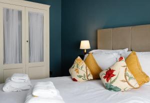 1 dormitorio con 1 cama con sábanas y almohadas blancas en Conyngham Arms Hotel, en Slane