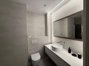 a bathroom with a sink and a toilet and a mirror at Moderno Piso Céntrico y Equipado in Torrellano +38 photos
