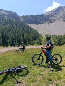 dos personas con bicicletas en un campo de hierba con una montaña en Cevedale-Valdisole, en Malè