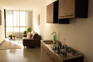 a kitchen with a sink and a stove top oven at Norte Cali - Bosque Living- 301 in Cali