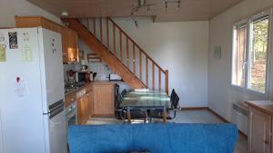 a kitchen with a blue couch and a table in a kitchen at Lieux-au-lac in Augignac
