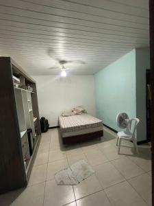 una stanza con un letto e una sedia di Casa ao ar livre ad Aracaju