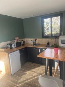 a kitchen with a wooden table and a counter top at Chalet détente proche plage in La Ciotat +14 photos