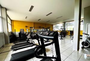 a gym with rows of treadmills and machines at CID305C Functional Apartment in Maringá