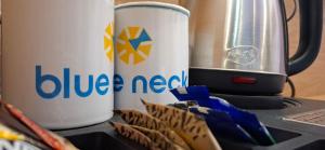 two white cups sitting on top of a blue needed blender at BlueNeck Ayodhya-Near ShriRam Mandir in Ayodhya