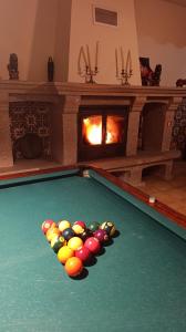 a pool table with a bunch of balls in front of a fireplace at Orion Guest Villa Casais in Lousada