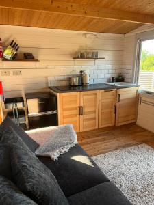 a living room with a couch and a kitchen at Ivy Rose Cabin No Hot Tub in Bude