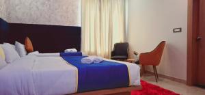 a hotel room with a bed with towels on it at BlueNeck Ayodhya-Near ShriRam Mandir in Ayodhya