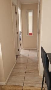 een hal met een spiegel, een tafel en een stoel bij olivos 1 in La Serena