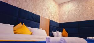 a bedroom with two beds with blue and yellow pillows at BlueNeck Ayodhya-Near ShriRam Mandir in Ayodhya