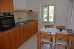 a kitchen with a sink and a table with chairs at Ferienhaus Moor-Rosl in Gamlitz
