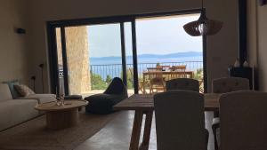 a living room with a table and chairs and a large window at Villa Castelina Part II of twin house in Vicani