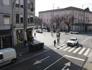 a city street with a white car parked on the street at PBH Hostel in Porto