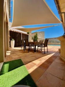 a patio with a table and chairs under an umbrella at Villas2meet Jimmy Lloret in Lloret de Vistalegre