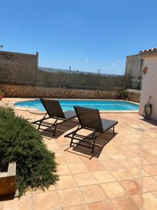 two lounge chairs sitting next to a swimming pool at Villas2meet Jimmy Lloret in Lloret de Vistalegre