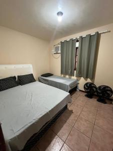 a bedroom with two twin beds and a window at CASA Secundaria COMPLETA COM PISCINA in Araruama