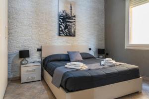 a bed in a bedroom with a brick wall at "La casa di Ryan" - Camere -Tra Cagliari e il Mare in Monserrato