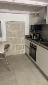 a kitchen with a stove and a stone wall at EGLHOUSE Locazioni brevi in Santa Croce Camerina