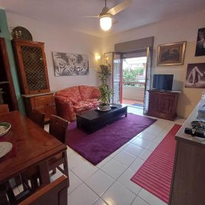 a living room with a red couch and a table at La casetta di Roger TRAPPITELLO in Taormina +25 photos