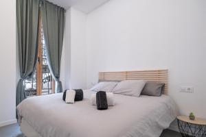 ein Schlafzimmer mit einem großen weißen Bett mit zwei Kissen in der Unterkunft ESC - Loft Valencia Cómodos y espaciosos estudios cercanos a estación Joaquín Sorolla in Valencia + 102 Fotos