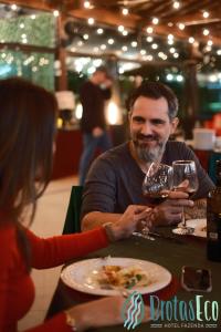 布罗塔斯Brotas Eco Hotel Fazenda的一男一女坐在桌边，手捧酒杯 更多118张照片