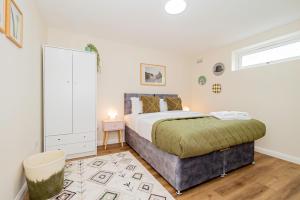 a bedroom with a large bed and a window at Modern 3-Bedroom 2-Bathroom Flat with Garden at Hanwell in Greenford