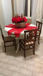 a table with a basket of red flowers on it at Casa Flea - Holiday apartment with 2 bedrooms in Gualdo Tadino +9 photos