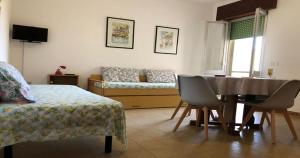 a living room with a table and a couch at Odegos Residence Torre dell'Orso in Torre dell'Orso