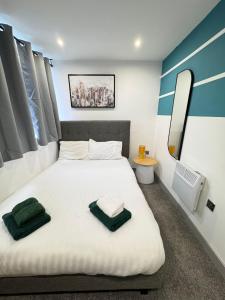 a bedroom with a large white bed with a mirror at Two Bedroom Flat by Brookland Stays Serviced Accommodation Short Lets Leeds with Free WiFi in Yeadon