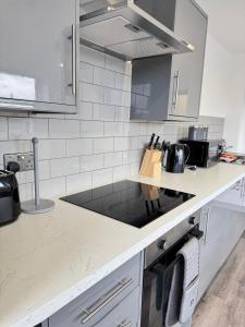 a kitchen with a counter top with a sink at Two Bedroom Flat by Brookland Stays Serviced Accommodation Short Lets Leeds with Free WiFi in Yeadon