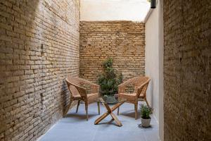 a patio with two chairs and a table and a brick wall at ESC - Loft Valencia Cómodos y espaciosos estudios cercanos a estación Joaquín Sorolla in Valencia