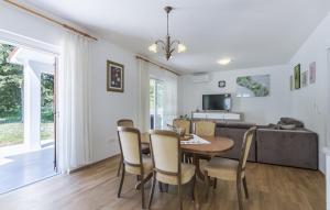 Un comedor y una sala de estar con mesa y sillas. en Beautiful Villa Ana with pool in Labin, en Labin