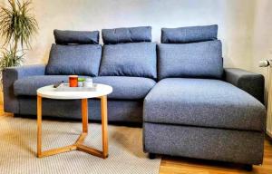 a living room with a blue couch and a table at HIRSCH FeWo Burgberg - Parkplatz - Zentral in Bad Harzburg