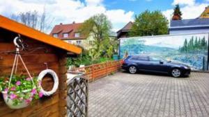 a car parked in a parking lot next to a fence at HIRSCH FeWo Burgberg - Parkplatz - Zentral in Bad Harzburg