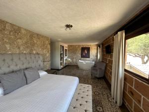 a bedroom with a bed and a bath tub and a bathroom at Cabañas Rancho San Jorge in Bernal
