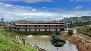 a building with a river in front of it at Pousada Várzea Grande in Pombos