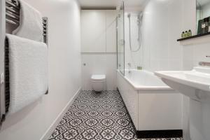 a white bathroom with a sink and a toilet at Marlin Canary Wharf in London