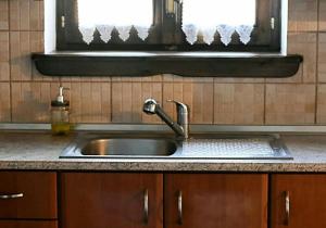 a stainless steel sink in a kitchen with a window at Stonehouse - The Secret Place in Vyzitsa
