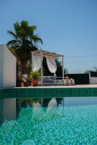vista sulla piscina con tavolo e aophethritisthritis di Quinta das Oliveiras a Olhão