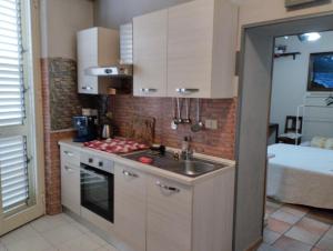 a small kitchen with a sink and a stove at Appartamento con cucina a Taormina centro con vista mare e su l'etna casa Muscolino in Taormina